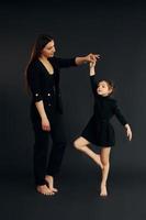 mère et fille sont ensemble dans le studio sur fond noir photo