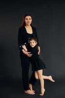mère et fille sont ensemble dans le studio sur fond noir photo