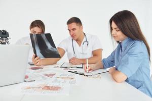 radiographie des jambes. groupe de jeunes médecins travaille ensemble dans le bureau moderne photo