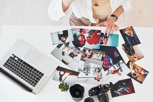 vue rapprochée de la table avec appareil photo et photos. femme photographe au travail