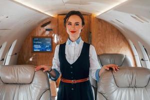 jeune hôtesse de l'air sur le travail dans l'avion passager photo