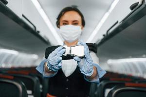 consignes de sécurité. jeune hôtesse de l'air sur le travail dans l'avion passager photo