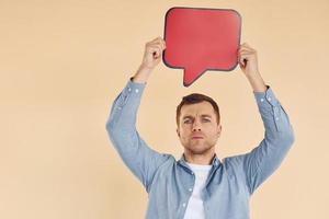 expression faciale. homme debout dans le studio avec des signes vides pour le texte photo