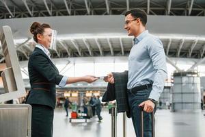 vérification des documents. jeune homme d'affaires en vêtements formels est à l'aéroport pendant la journée photo