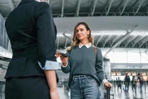 avec des papiers. jeune femme touriste est à l'aéroport pendant la journée photo