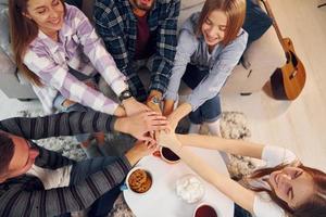 s'amuser. un groupe d'amis fait la fête ensemble à l'intérieur photo