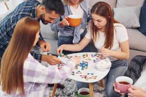 jouer à un jeu de puzzle. un groupe d'amis fait la fête ensemble à l'intérieur photo