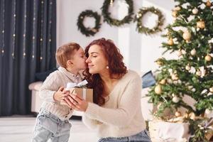 mère avec son petit fils est à la maison. décorations de Noël photo