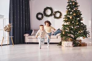 passer du temps actif. le petit frère et la soeur sont ensemble à la chambre décorée de noël photo