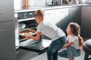 cuisson des aliments. petit garçon et fille préparant des biscuits de noël dans la cuisine photo