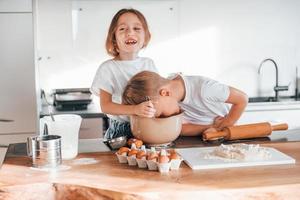 préparer des biscuits de Noël. petit garçon et fille dans la cuisine photo