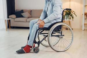 essayant de bouger. l'homme handicapé en fauteuil roulant est à la maison photo