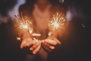 profiter de la main féminine avec une explosion de cierge magique en fête du nouvel an photo