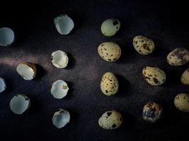 oeufs de caille de caille, une collection d'oeufs de caille sur une plaque de bois avec un fond de sable noir photo