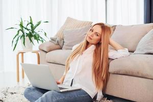 jeune femme en chemise blanche et jeans est à la maison photo