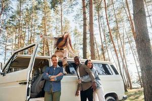 lieu de destination. un groupe de jeunes voyage ensemble dans la forêt pendant la journée photo