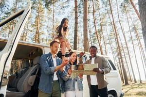 à l'aide de la carte. un groupe de jeunes voyage ensemble dans la forêt pendant la journée photo