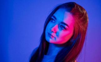 portrait de jeune femme à la mode qui se tient dans le studio avec néon photo