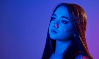 jeune femme à la mode debout dans le studio avec néon photo