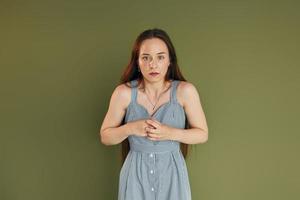 jeune femme effrayée dans des vêtements décontractés debout à l'intérieur dans le studio photo