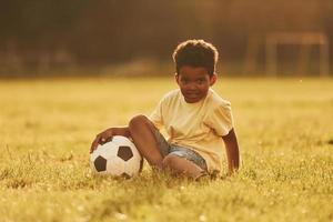 beau soleil. un enfant afro-américain s'amuse sur le terrain pendant la journée d'été photo