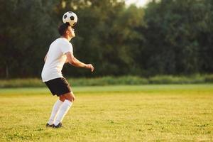 journée d'été. jeune footballeur s'entraîne sur le terrain sportif photo