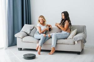 assis sur le lit. deux femmes sont ensemble à la maison photo