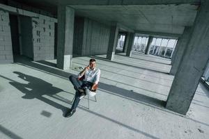 un jeune homme en tenue de soirée qui réussit travaille à l'intérieur sur la construction photo