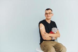 portrait d'homme en chemise noire assis après la vaccination photo