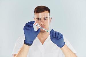 jeune homme médecin en uniforme est à l'intérieur sur fond blanc photo