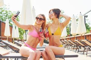 les amis passent du bon temps. les femmes en maillot de bain s'amusent ensemble à l'extérieur en été photo