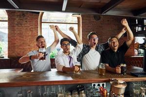 par le tableau. gens en vêtements décontractés assis dans le pub photo