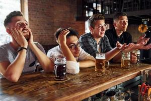 Fans de football. gens en vêtements décontractés assis dans le pub photo