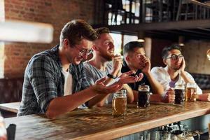 fans de football. gens en vêtements décontractés assis dans le pub photo