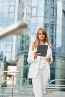 contre la création d'entreprise. femme en tenue de soirée debout à l'extérieur de la ville pendant la journée photo