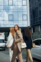 les femmes positives en tenue de soirée sont à l'extérieur de la ville ensemble photo