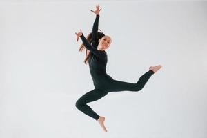 exercices professionnels. jeune femme en vêtements sportifs faisant de la gymnastique à l'intérieur photo