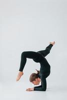 exercices difficiles. jeune femme en vêtements sportifs faisant de la gymnastique à l'intérieur photo