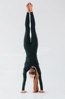 exercices professionnels. jeune femme en vêtements sportifs faisant de la gymnastique à l'intérieur photo