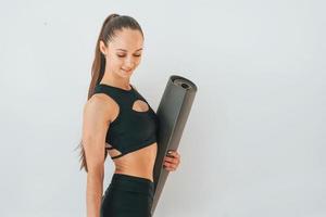 prêt pour les exercices. jeune femme en vêtements sportifs faisant de la gymnastique à l'intérieur photo