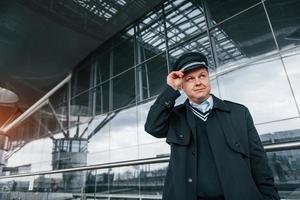 pilote en uniforme debout à l'extérieur près du bâtiment de l'aéroport photo