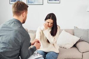 jeune femme lors d'une réception chez un psychologue. pleurer et parler de problèmes photo