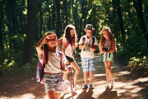 fille regardant au loin. enfants se promenant dans la forêt avec équipement de voyage photo