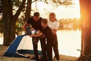 la famille de la mère, du père et des enfants est sur le camping photo