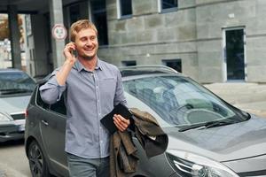 parler au téléphone. homme se promenant à l'extérieur de la ville pendant la journée photo