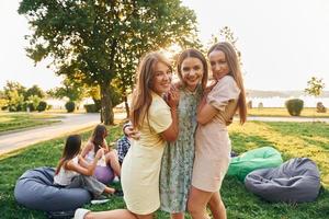 des femmes qui s'embrassent. un groupe de jeunes fait la fête dans le parc pendant la journée d'été photo