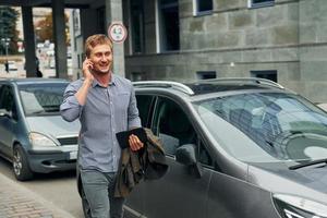 parler au téléphone. homme se promenant à l'extérieur de la ville pendant la journée photo