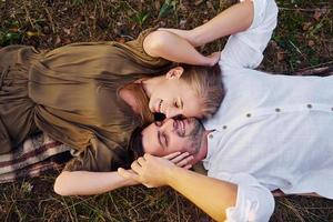 couple heureux est à l'extérieur allongé sur le sol photo