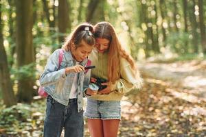 deux filles dans la forêt verte pendant la journée d'été ensemble photo