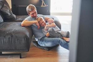 avoir du temps libre. père et fils sont à l'intérieur à la maison ensemble photo